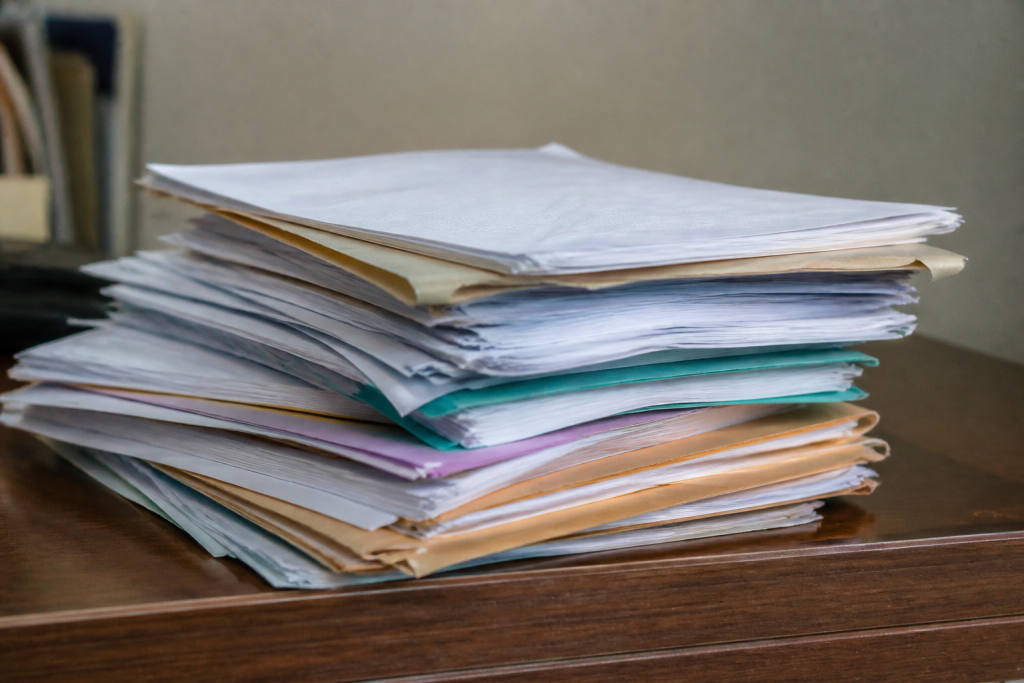 Dossier administratif avec documents immobiliers et formulaires empilés