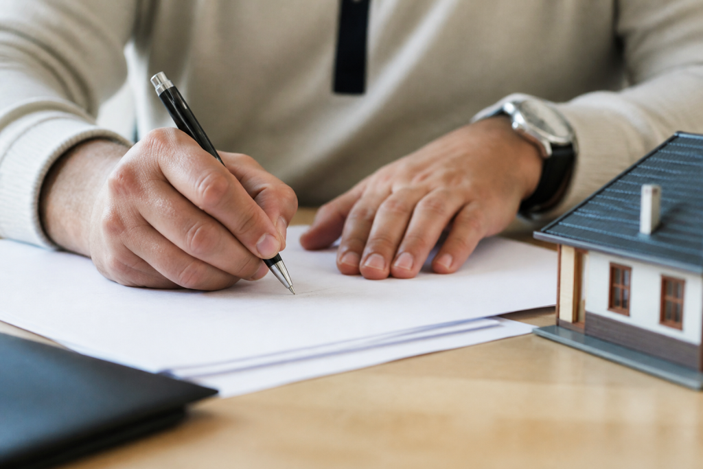 Contrat immobilier signé avec stylo sur documents officiels
