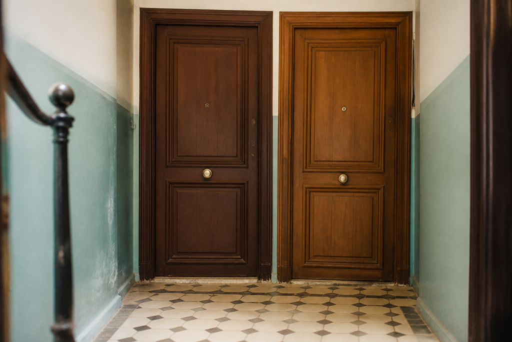 Deux portes d'appartement cote a cote dans couloir immeuble