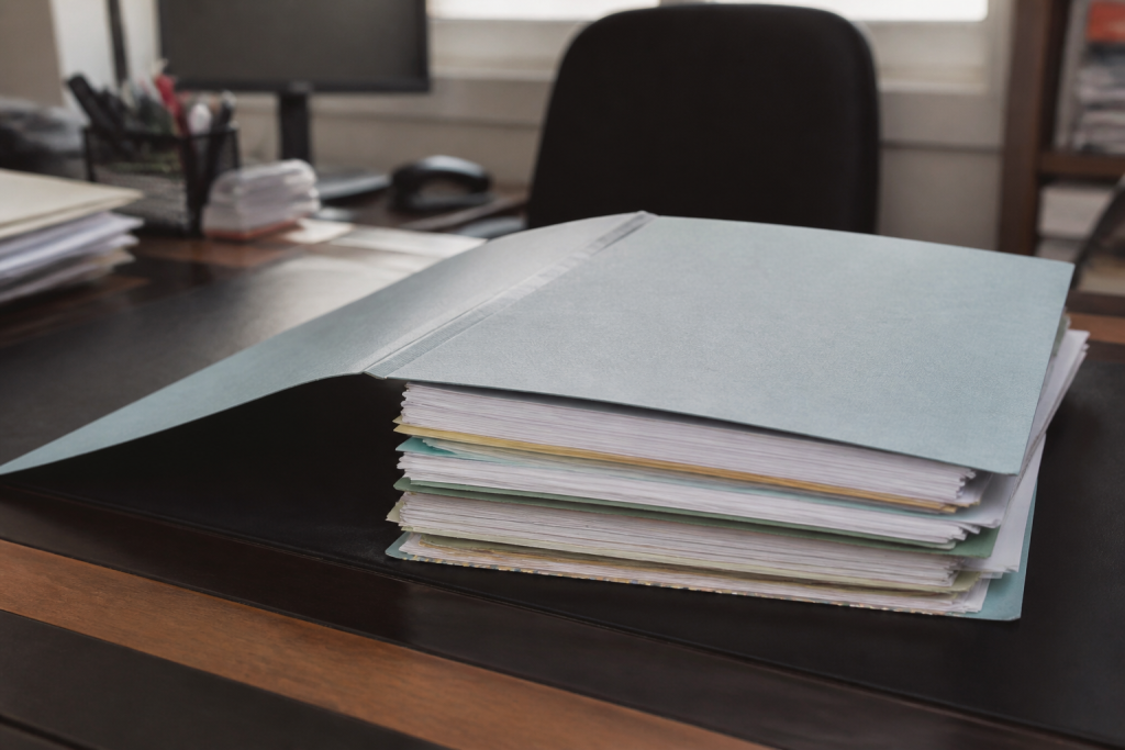 Dossier immobilier ouvert sur bureau avec documents administratifs empilés
