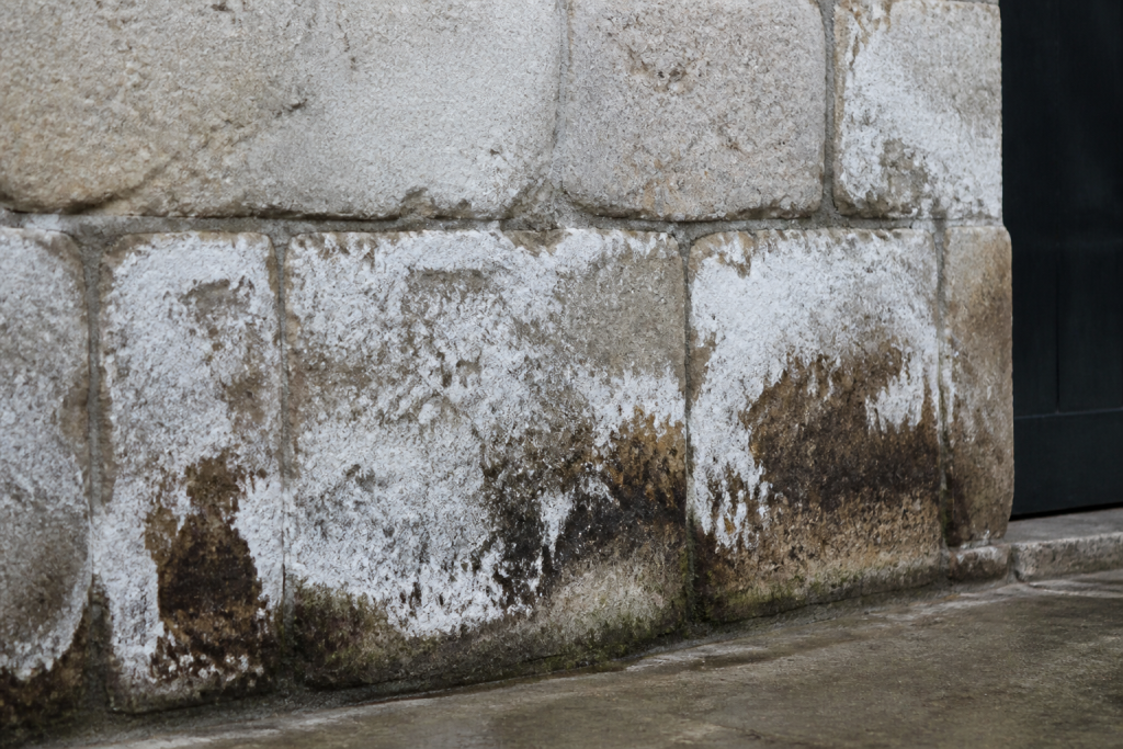 Pierre ancienne avec efflorescence blanche et traces humidite